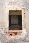 Otwór okienny w elewacji frontowej pałacu – widoczne zdewastowane wnętrze, pozbawione stropów.